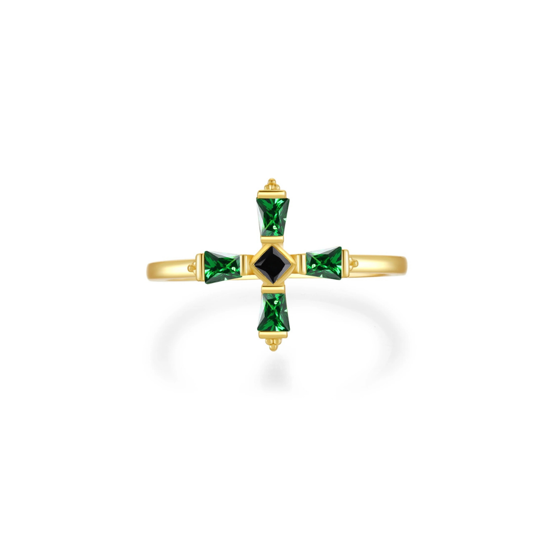 Gold cross-shaped ring with green gemstones on a white background