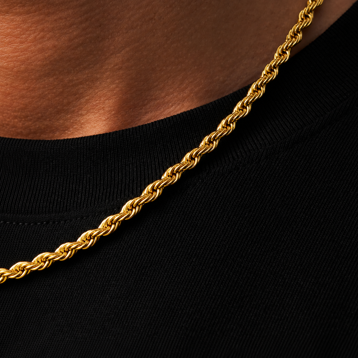 Gold rope chain necklace on a black background