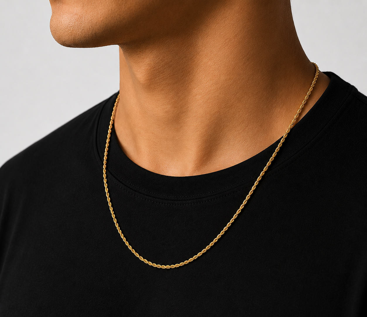 Person wearing a Ezro gold chain necklace on a plain background
